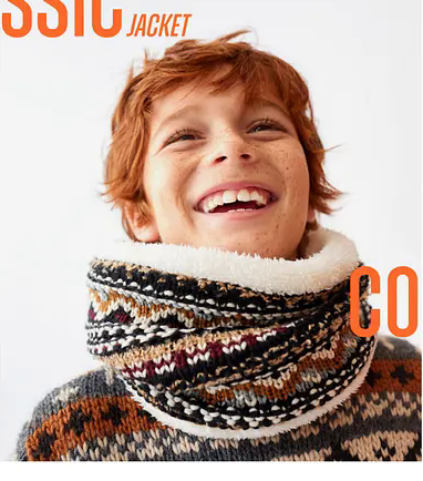 Smiling child wearing a patterned knit sweater and oversized scarf.